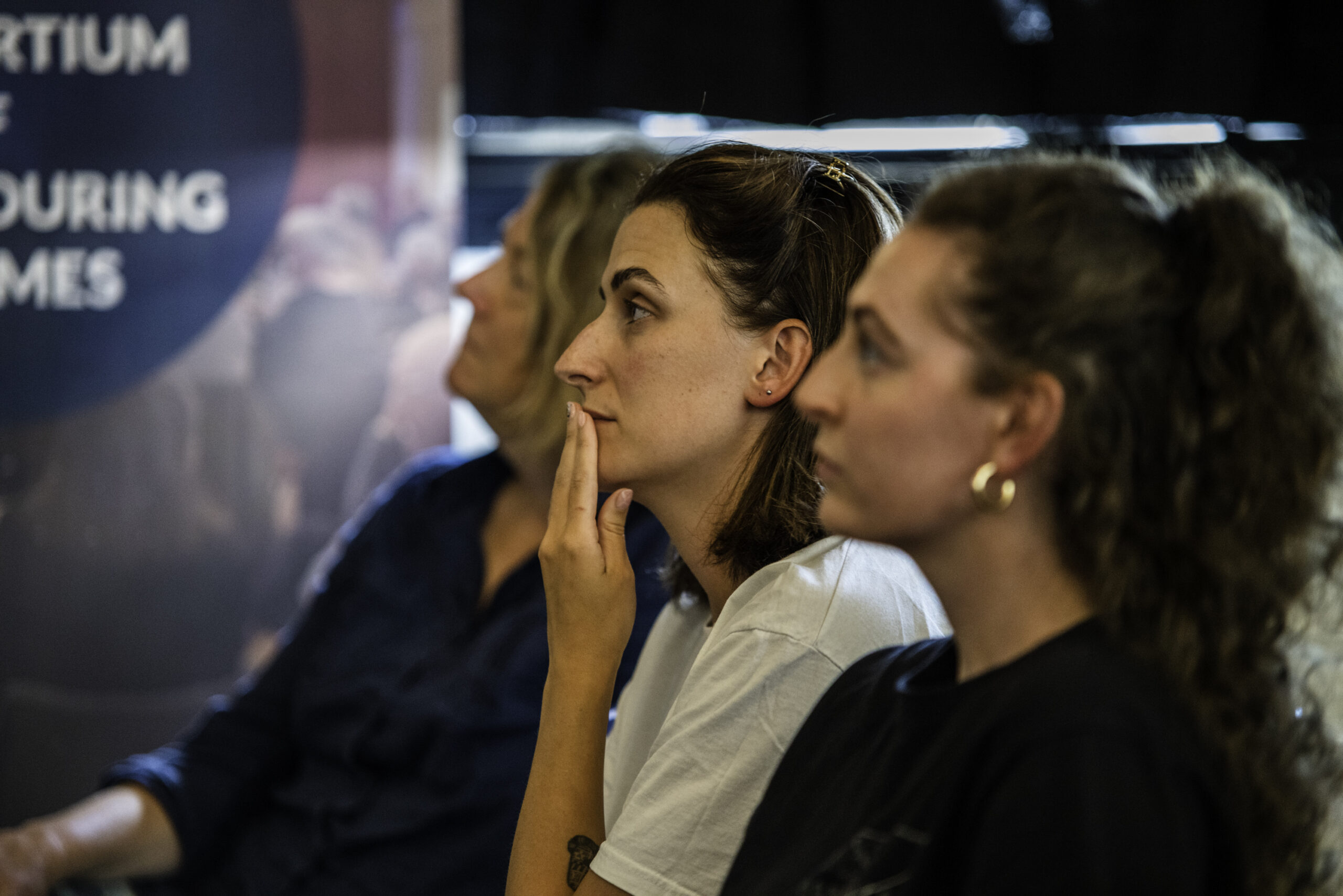 A trio of women listen to a talk at the HANDS event